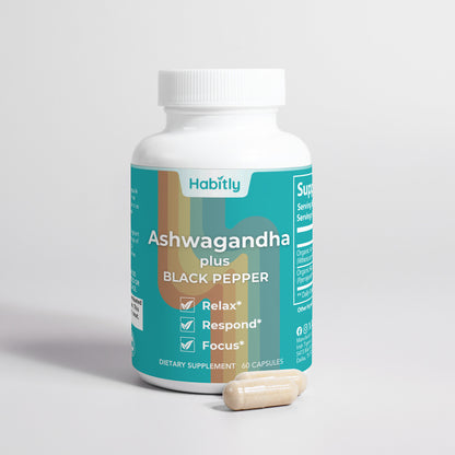 A white bottle of dietary supplement labeled &quot;Habitly Ashwagandha with Black Pepper,&quot; featuring a teal and orange design. The bottle claims it helps you to &quot;Relax,&quot; &quot;Respond,&quot; and &quot;Focus.&quot; As an adaptogen, this supplement is displayed with two white capsules beside it.