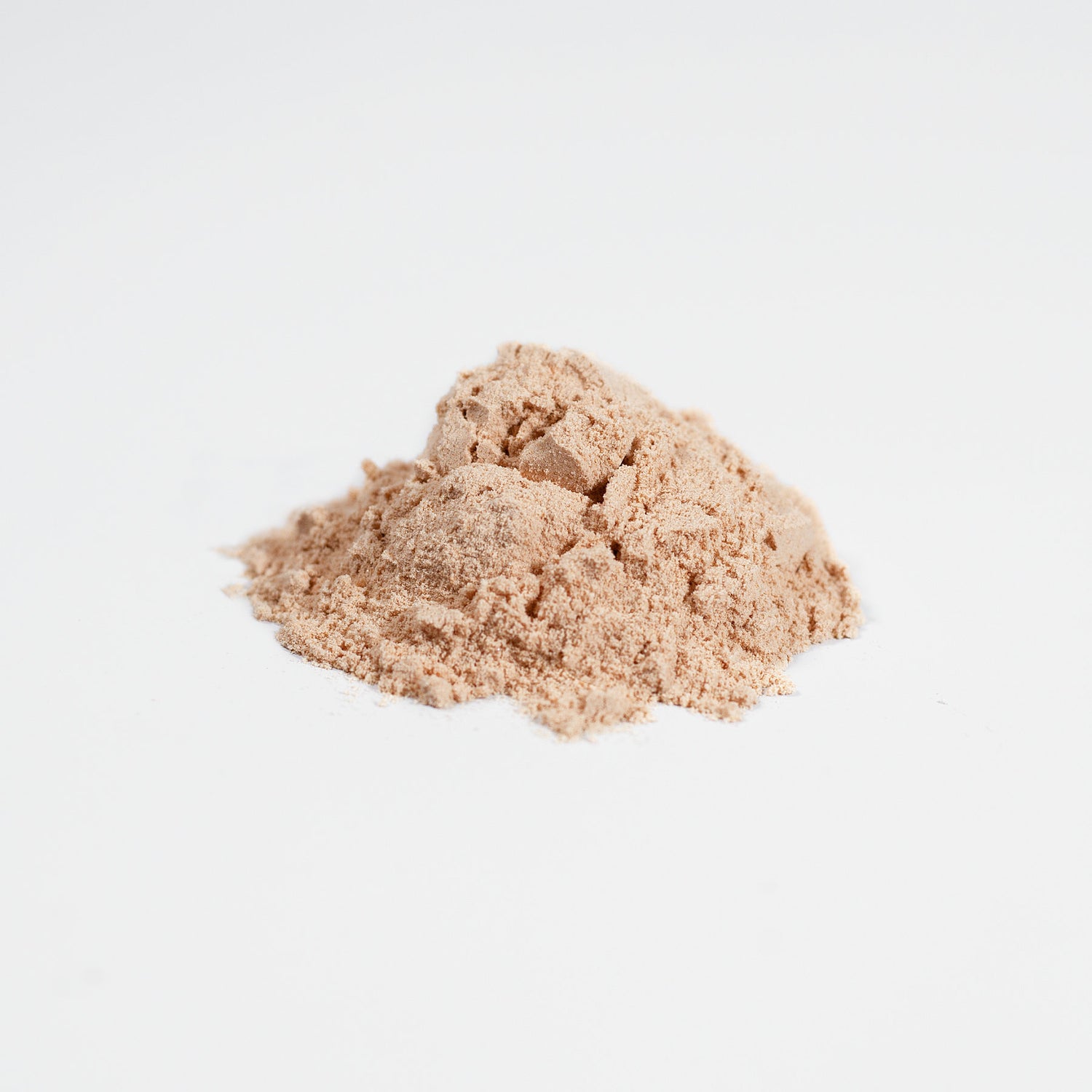 A small mound of finely ground, light brown powder from the Habitly Biome Fermented Mushroom Blend rests on a white surface, displaying a slightly textured appearance.