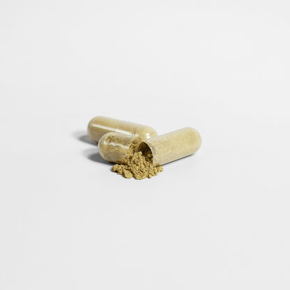 On a pristine white background, two Pure Moringa Leaf Capsules by Habitly lie side by side, one partially open with beige powder spilling out. It hints at the potency of dietary supplements, potentially enriched with antioxidants from Moringa Oleifera.