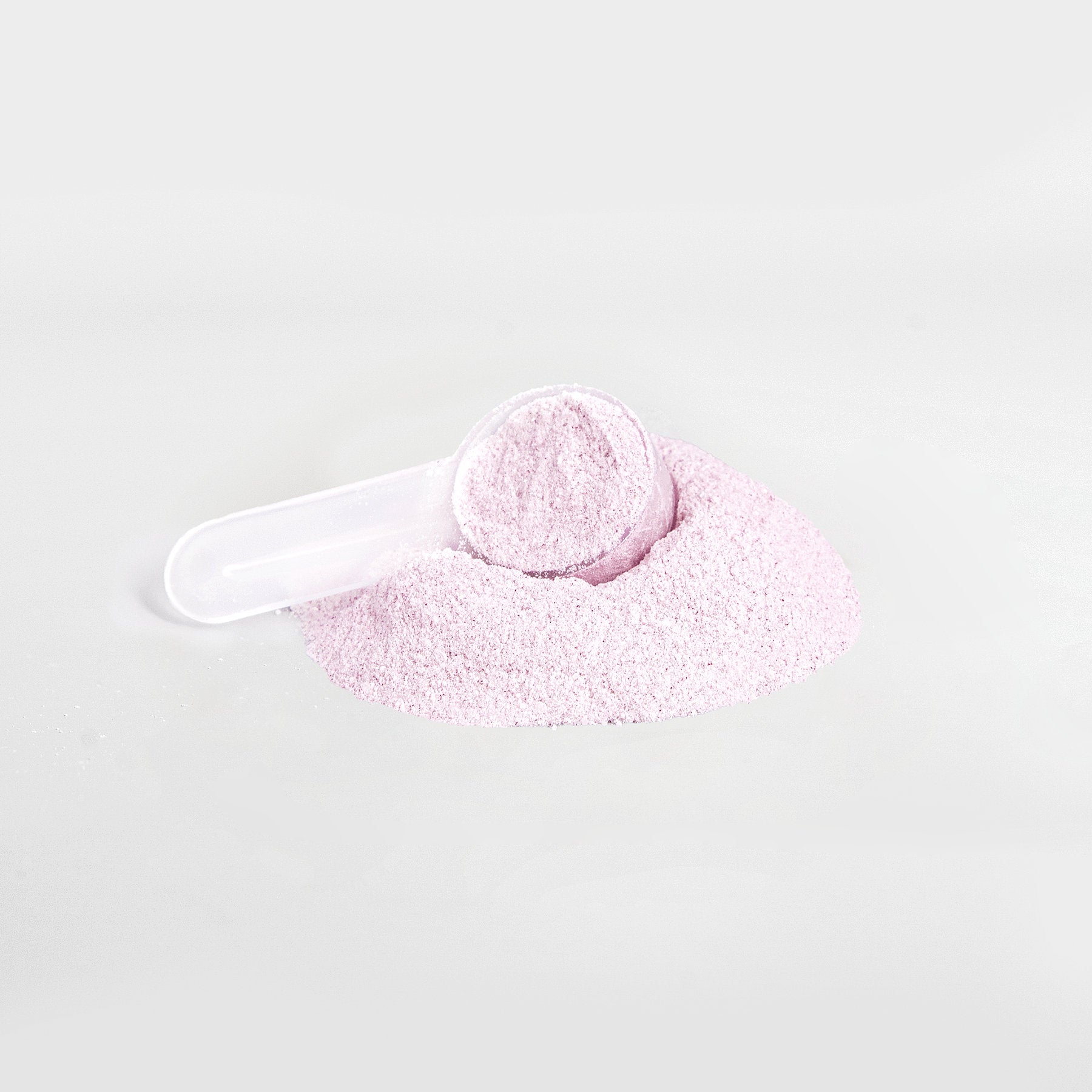 A small white scoop sits in a pile of light pink Habitly&