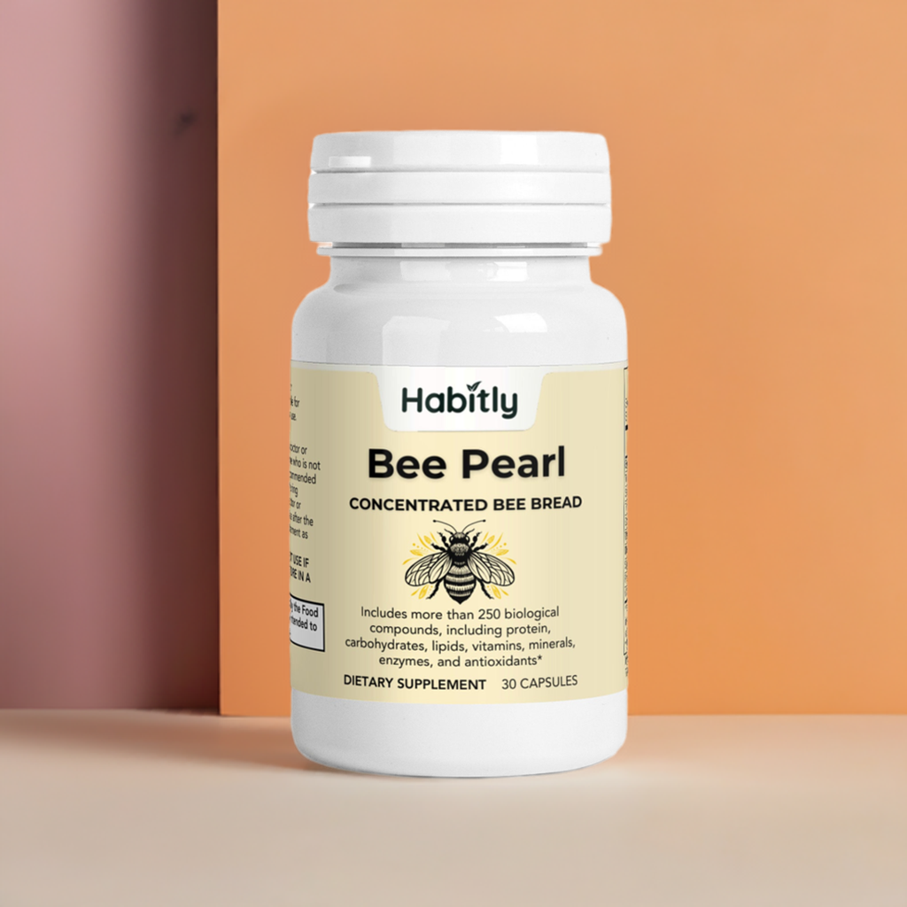 A white bottle labeled &quot;Bee Pearl Concentrated Bee Bread Capsules&quot; from the brand Habitly rests against a two-tone peach background. This gluten-free dietary supplement contains over 250 biological compounds and essential vitamins, with the bottle holding 30 capsules.