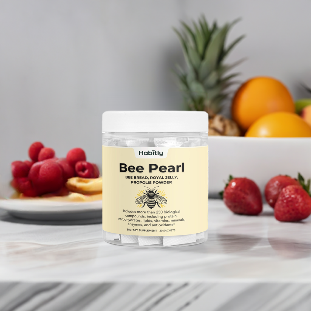 A container labeled &quot;Bee Pearl Concentrated Bee Bread Powder&quot; from Habitly is placed on a marble countertop. Behind it, there&