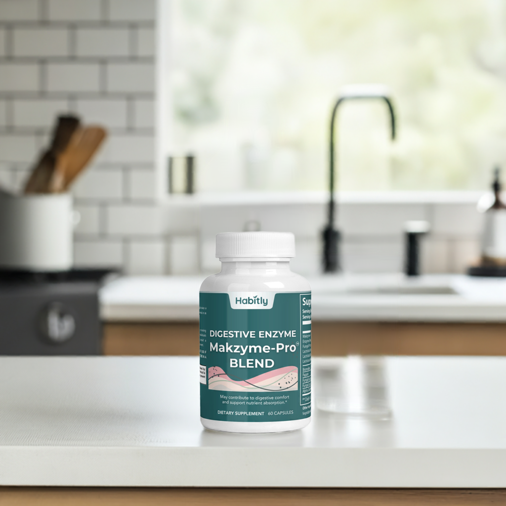 A container of &quot;Digestive Enzymes Pro Blend with Makzyme-Pro&quot; by Habitly rests on a kitchen counter, providing essential digestive enzymes. In the soft-focus background, a sink and utensils add to the setting.